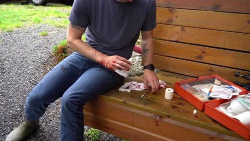 Man Treating Bloody Hand Wound Outdoors