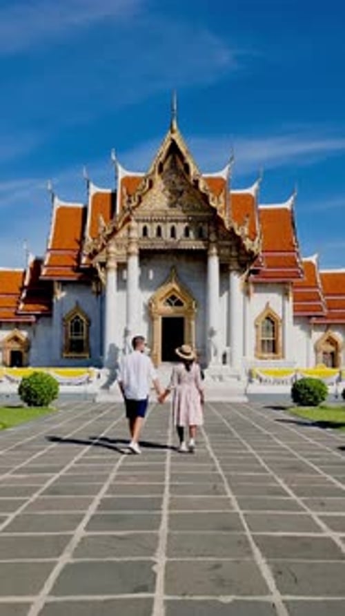 Couple Exploring the Stunning Wat Benchamabophit in Bangkok Thailand on a Sunny Day