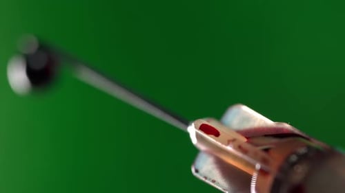 Syringe close up with needle droplet out of focus