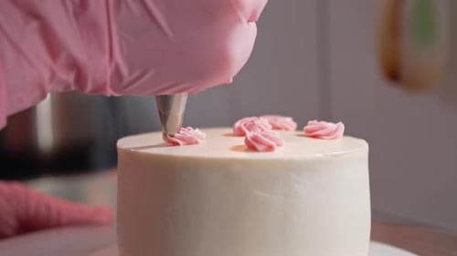 Decorating a cake with frosting roses close up