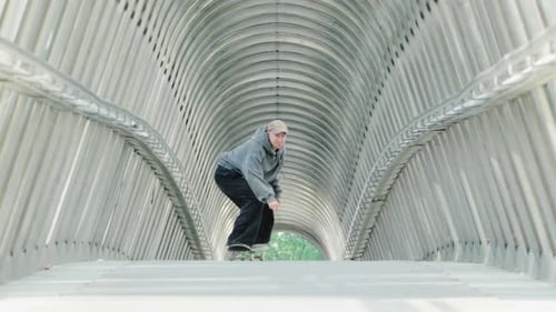 Skateboarder Performing Tricks in a Tunnel