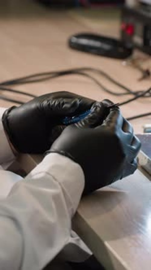Technician Adjusting Screw with Electronic Component Under Microscope