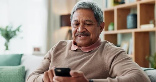 Senior Man Uses Smartphone in Bright Home
