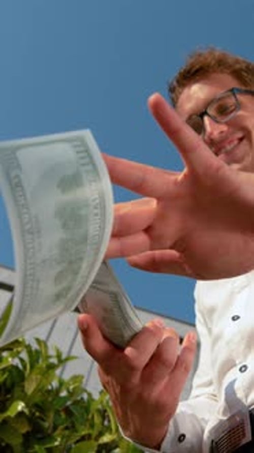 American businessman holding hundred dollar bill.