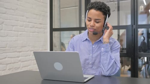 Young African Woman with Headset Talking Online with Customer in Call Center