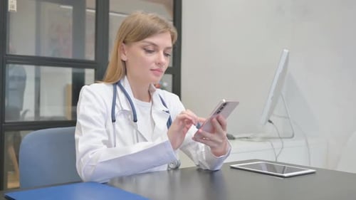 Doctor Using Smartphone at Desk in Office