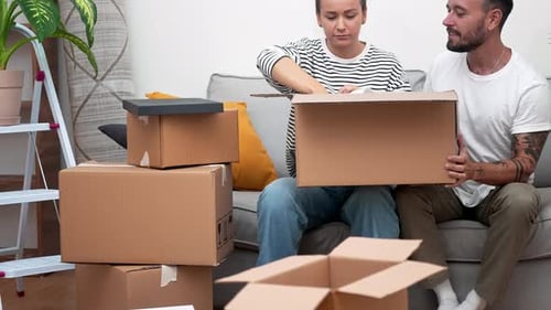 Couple Excited Moving Day Unpacking Belongings in New Home Concepts of Relocation and Real Estate