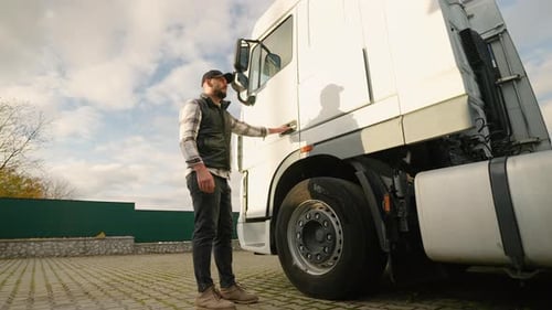 Truck Driver Opens Door and Enters White Lorry