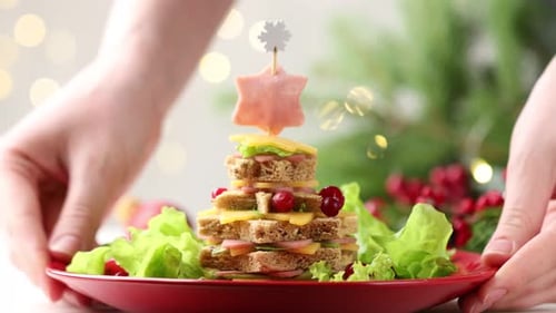 Christmas food. Woman with fir tree made of bread, cheese, ham, lettuce and decor at table