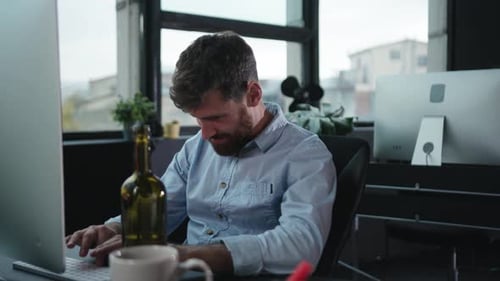 A Dedicated and Focused Professional is Working Late Into the Evening at a Modern Office