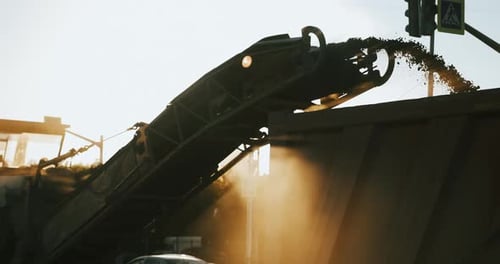Road construction works on sunset. Asphalt removing with milling grinding machine