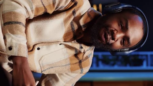 Vertical Video Man Recording Interview with Professional Camera in Studio Reviewing Notes to Ask