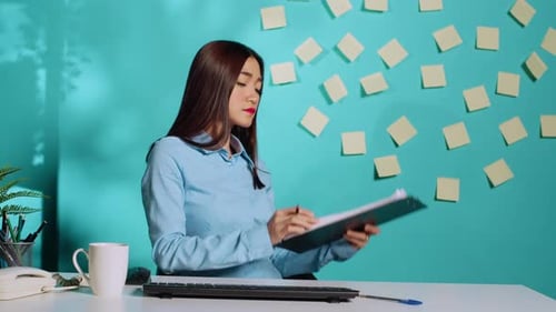 Woman Reviews Documents at Computer Desk