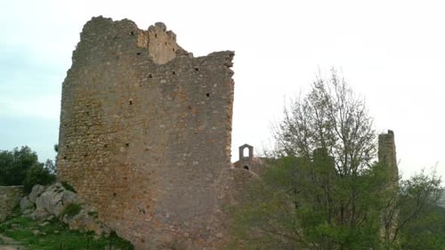 Ruined castle in Europe aerial footage cinematic medieval era Close-up of the distributed wall, smo