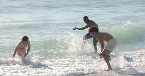 Diverse friends enjoy a game in the ocean waves