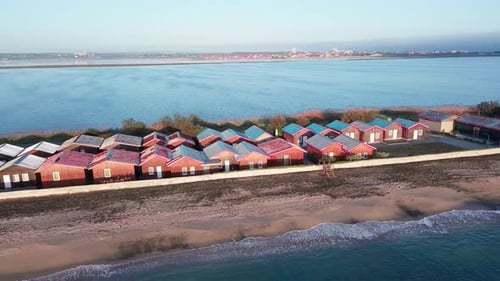 Aerial View of the Shore with Grass and Houses Surrounded By the Black Sea Under a Clear Sky in