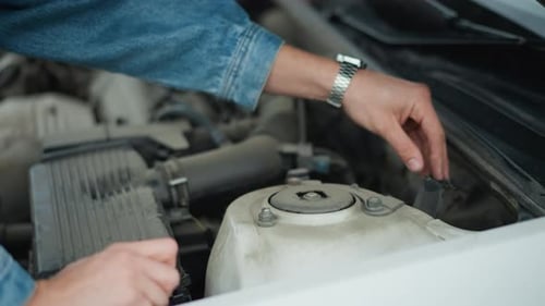 Mechanic working on car engine in garage