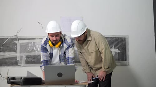 Designers Chief Engineer Analyze the Repair Project on a Laptop