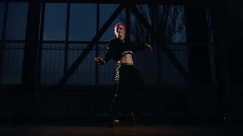 Stilvolles Mädchen übt abends Hip-Hop-Schritte im Tanzstudio.
Jung