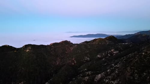 Luftbild von Bergen über niedrigen Wolken in der Morgendämmerung