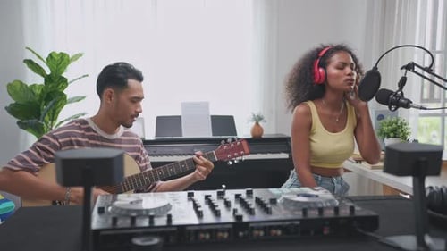 Diverse young stylish audio producer working in the music record studio.