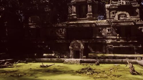 Ancient Cambodian Temple Ruins Amid Lush Greenery and Stagnant Water