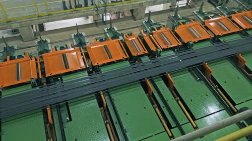 Automated handling system using roller or chain conveyors to move long metal profiles in factory