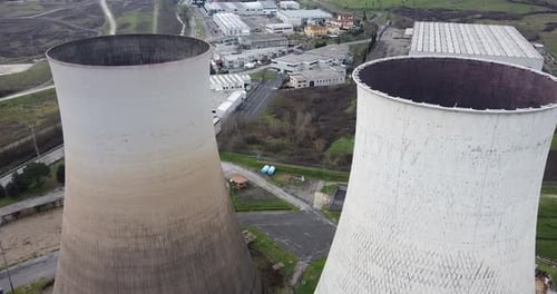 Aerial approaching the middle of two Santa Barbara power station cooling towers. Cloudy day, Winter