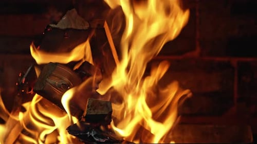 Roaring Fireplace with Burning Logs in Dark Interior