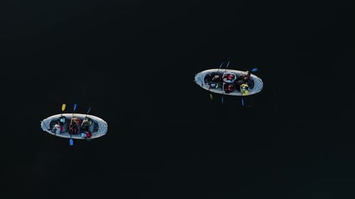 Drone shot directly down to the lake with two boats and people