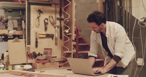 4k video footage of a handsome young male carpenter working in his woodworking workshop