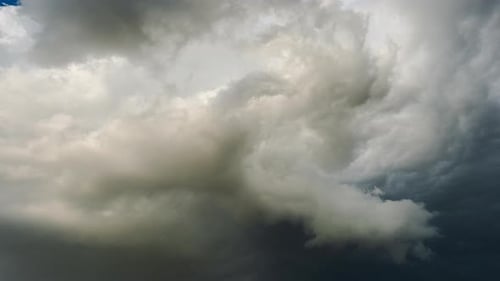 Dicke graue Sturmwolken, die sich über den Himmel bewegen, zeigen sich entwickelnde Wettersysteme