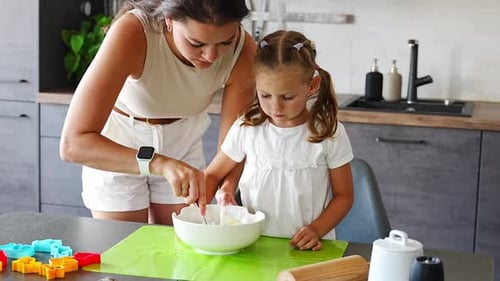 Mother and Child Cooking Together in Kitchen