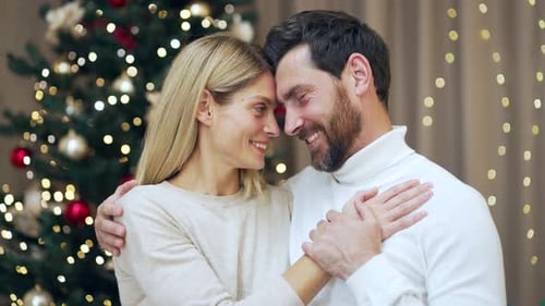 Married couple hugs on Christmas Eve or New Year holidays in cozy house indoors at home Evening.