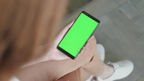 Young woman using smartphone mockup for advertisement or chroma key tracking