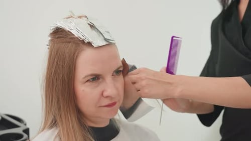 Woman Receiving Hair Treatment at Salon with Foil