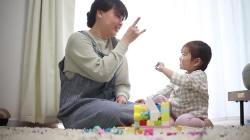 Woman and Child Playfully Interacting with Building Blocks