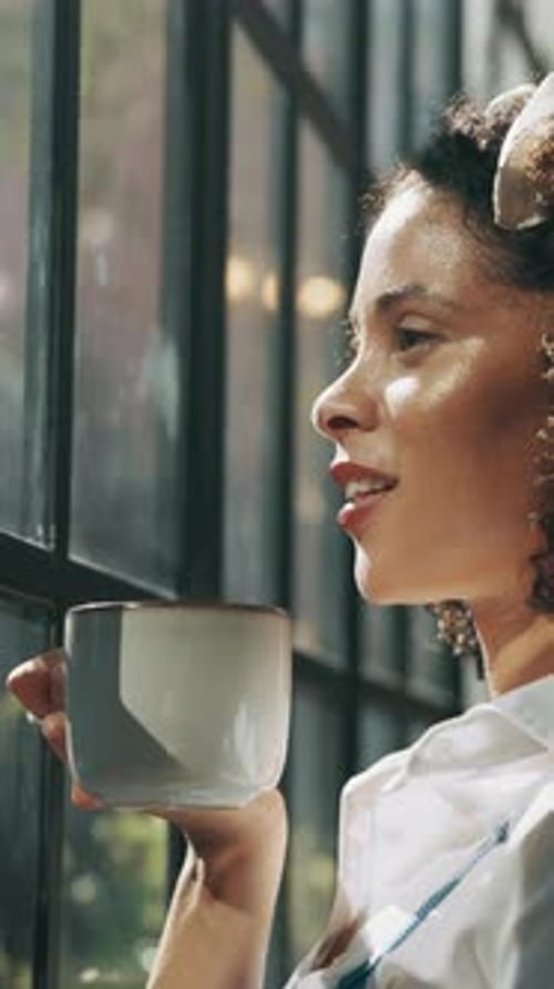 Woman Drinking Coffee Standing By Window Portrait
