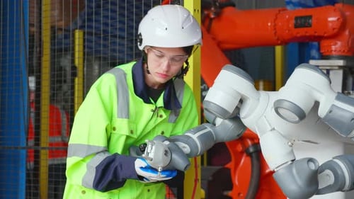 Junge Ingenieurin überprüft und gewartet Maschinen, Roboter, Waffen, Technologie in der Fabrik.