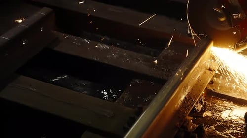 Industrial Closeup of a Handheld Abrasive Saw Cutting a Steel Rail with Bright Sparks Flying