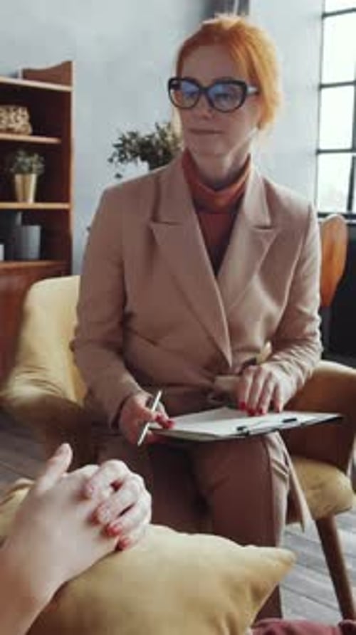 Red Haired Woman Interviewing Person Lying on Couch