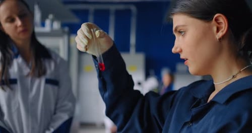 Scientist Holding Red Sample in Laboratory