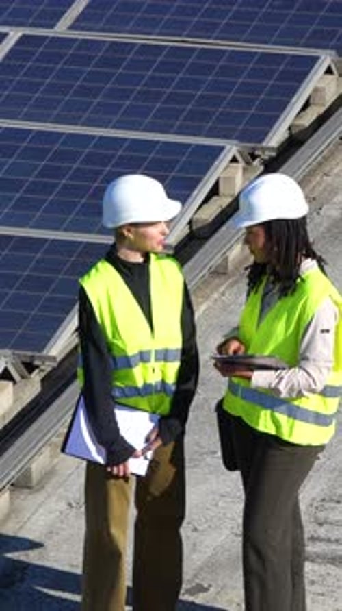 Ingenieurinnen installieren Sonnenkollektoren auf dem Dach