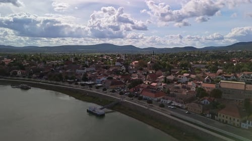 Drohne fliegt vorwärts in Richtung Szentendre mit den bezaubernden roten Dächern und der Donaupromenade.