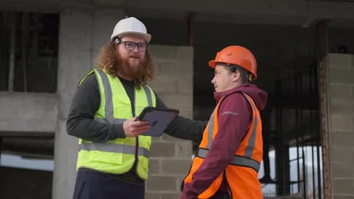 Construction Workers Discussing Project on Construction Site