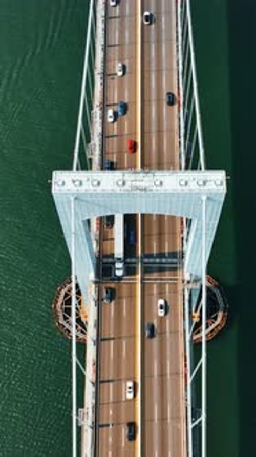 Rising above the support of suspension bridge. Numerous cars run quickly by the roads on the bridge