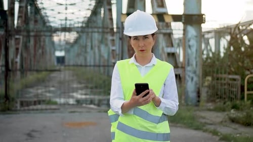 Woman Engineer With Phone at Industrial Site