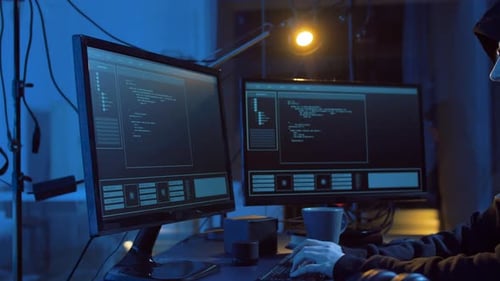 Young hacker in dark room creates cyber attack code for dangerous cybercrime