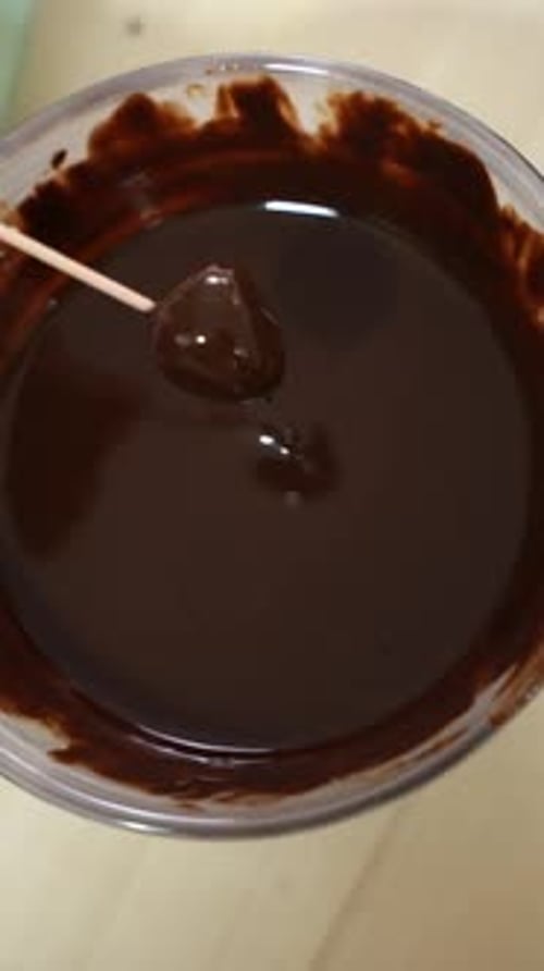 Dipping Ball on a Stick in Melted Chocolate