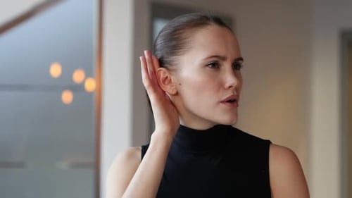 Woman Listens Intently, Hand Cupped to Ear